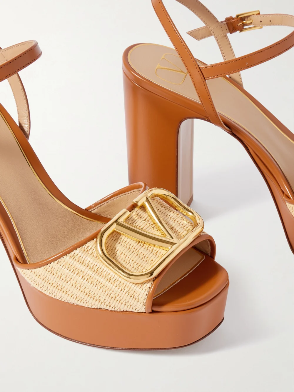 Close-up detail of the Valentino Garavani Vlogo Signature 115 Leather-trimmed Raffia Platform Sandals