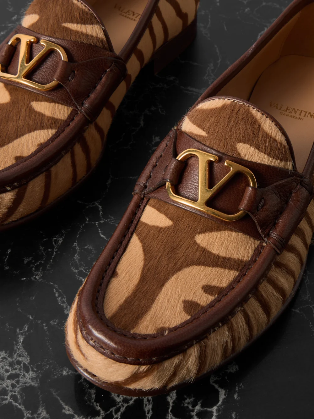 Close-up detail of the Valentino Garavani Vlogo Signature 20 Leather-trimmed Zebra-print Calf Hair Loafers