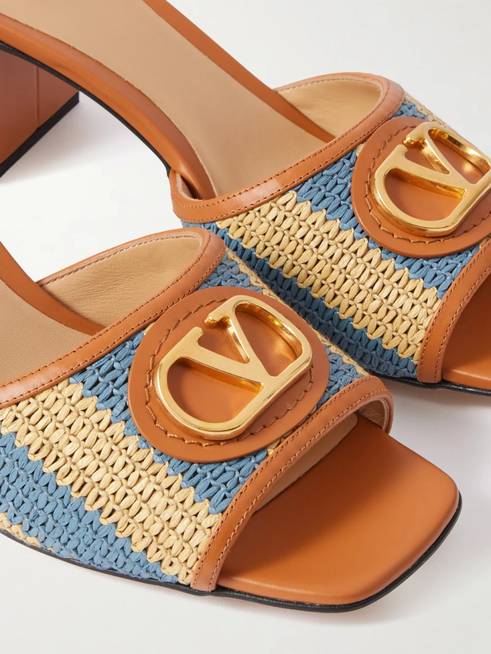 Close-up detail of the Valentino Garavani Vlogo Signature 60 Leather-trimmed Striped Raffia Mules
