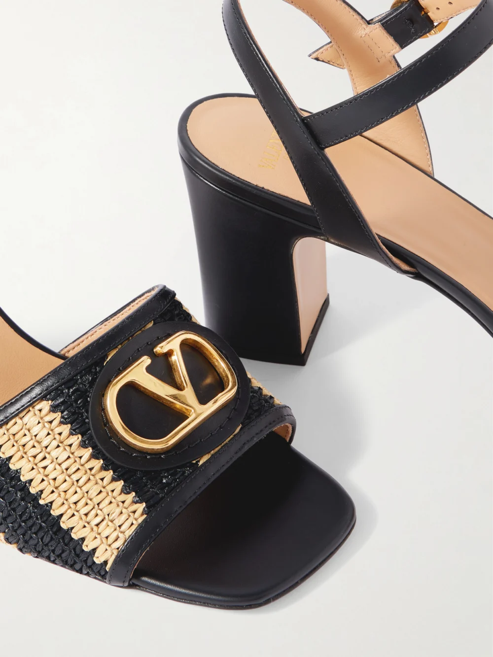 Close-up detail of the Valentino Garavani Vlogo Signature 75 Embellished Leather-trimmed Striped Raffia Sandals