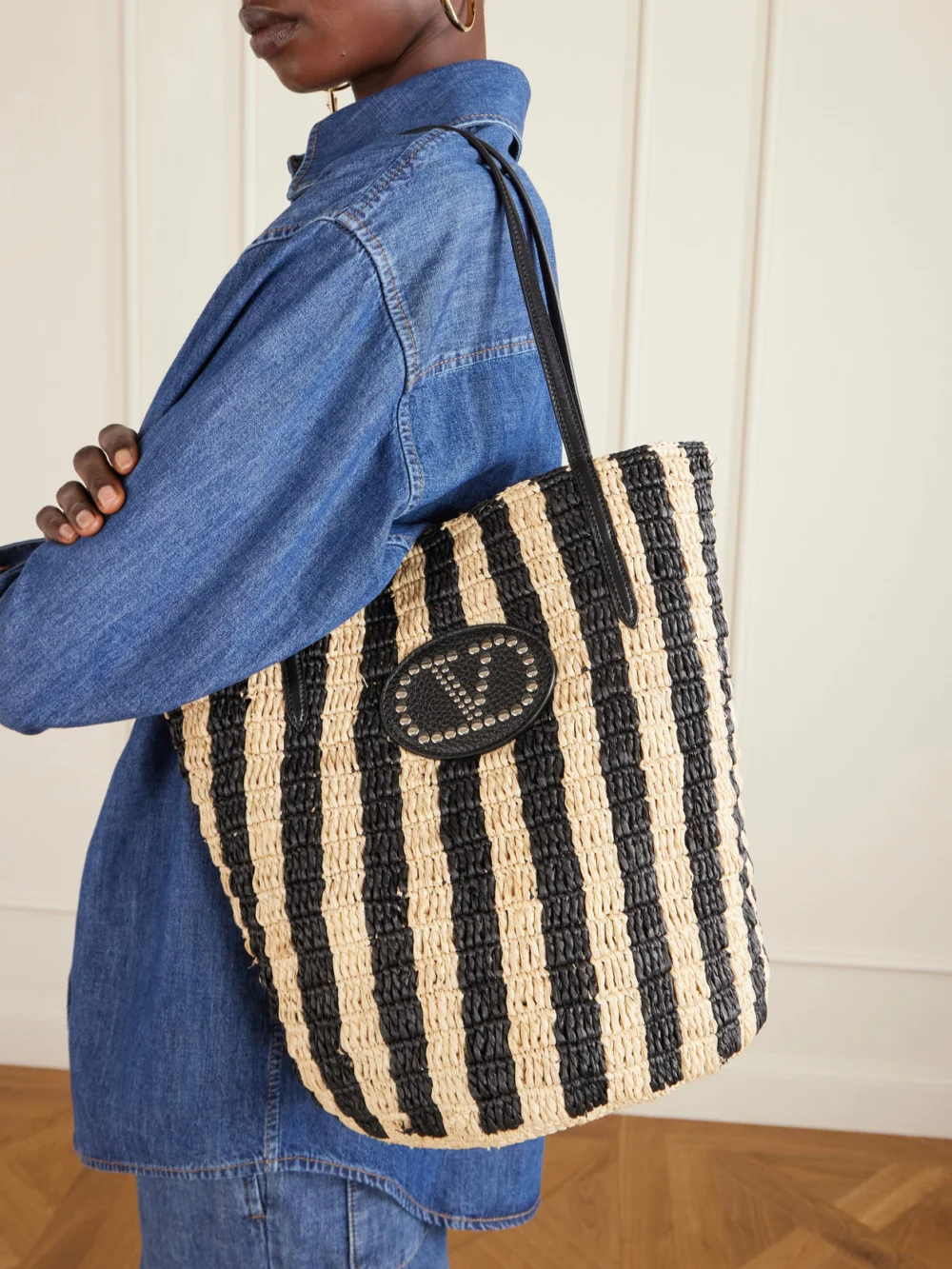 Valentino Garavani Vlogo Signature Small Leather-trimmed Striped Raffia Bucket Bag, styled view
