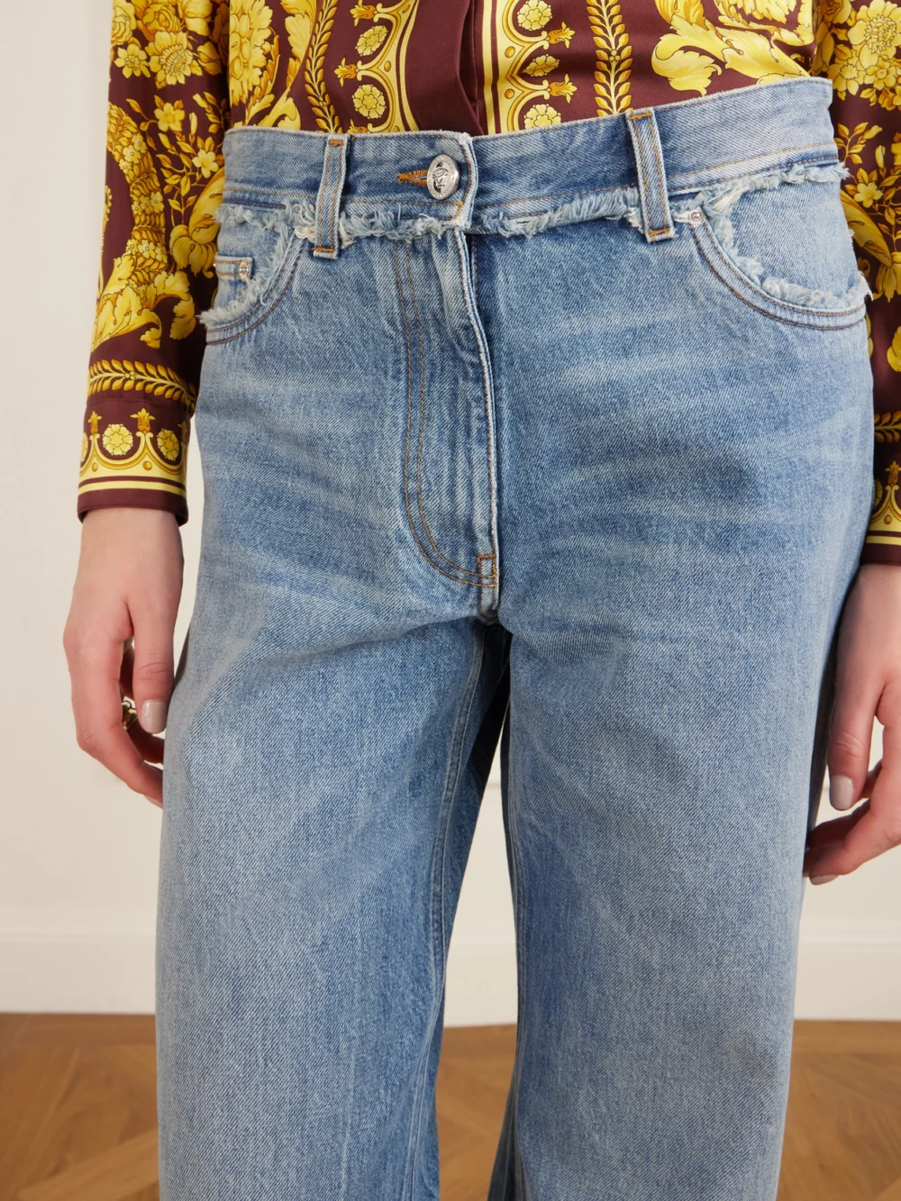 Close-up detail of the Versace Distressed Mid-rise Straight-leg Jeans