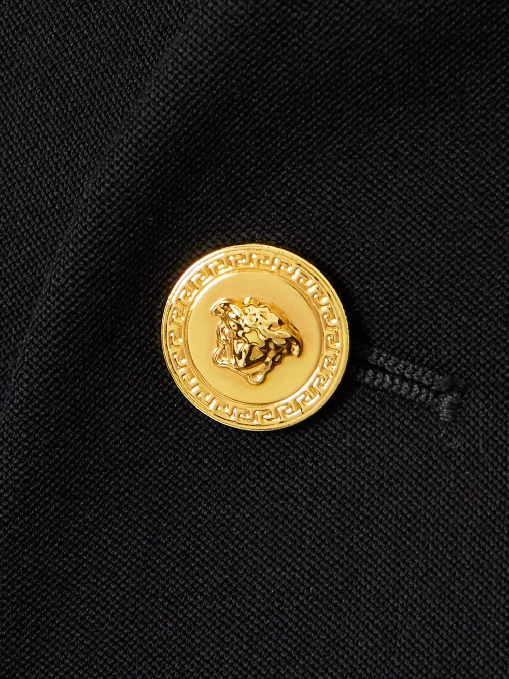 Close-up detail of the Versace Double-breasted Grain De Poudre Wool Mini Dress