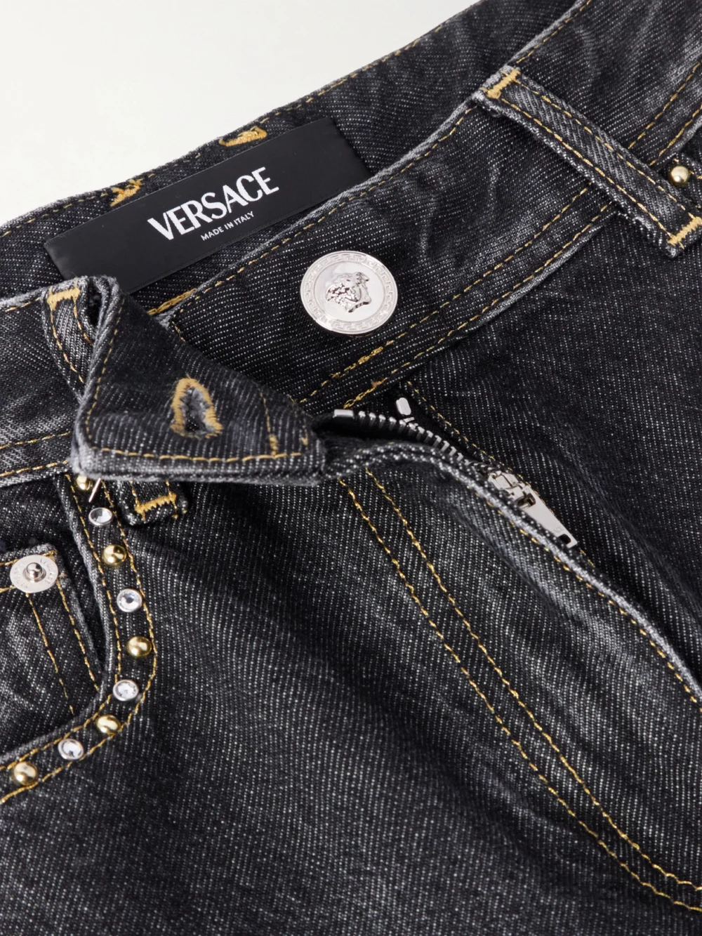 Close-up detail of the Versace Embellished High-rise Straight-leg Jeans
