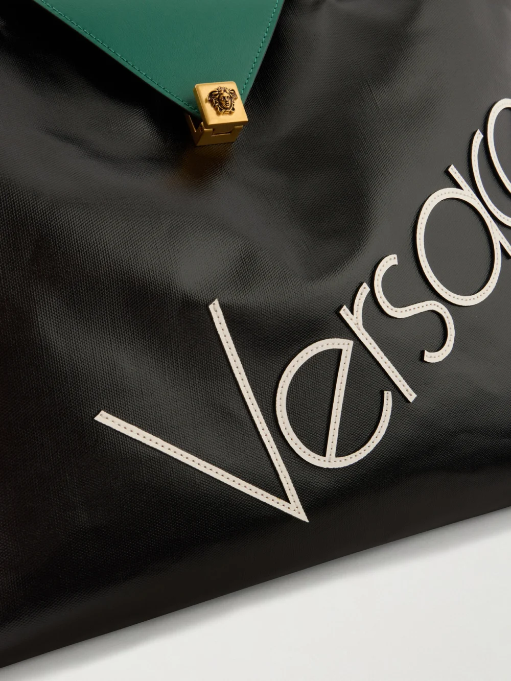 Close-up detail of the Versace Logo-appliquéd Leather-trimmed Coated-canvas Tote