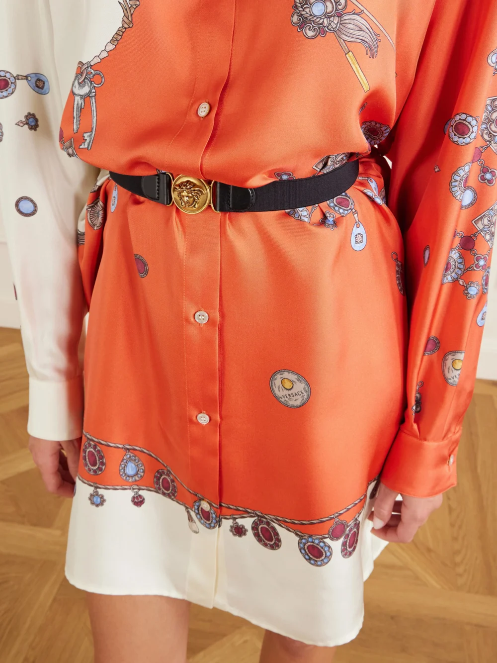 Close-up detail of the Versace Stolen Jewels Medusa-embellished Belted Printed Silk-twill Mini Dress