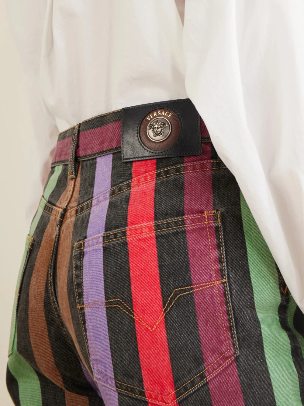 Close-up detail of the Versace Striped Mid-rise Straight-leg Cotton Jeans