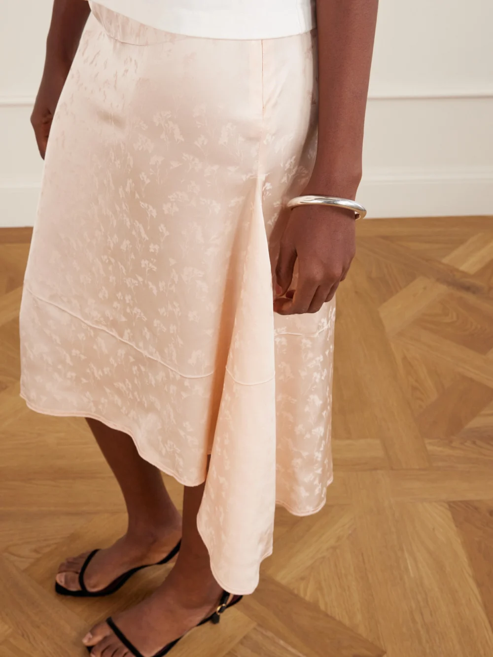 Close-up detail of the Victoria Beckham Asymmetric Floral-jacquard Satin Midi Skirt