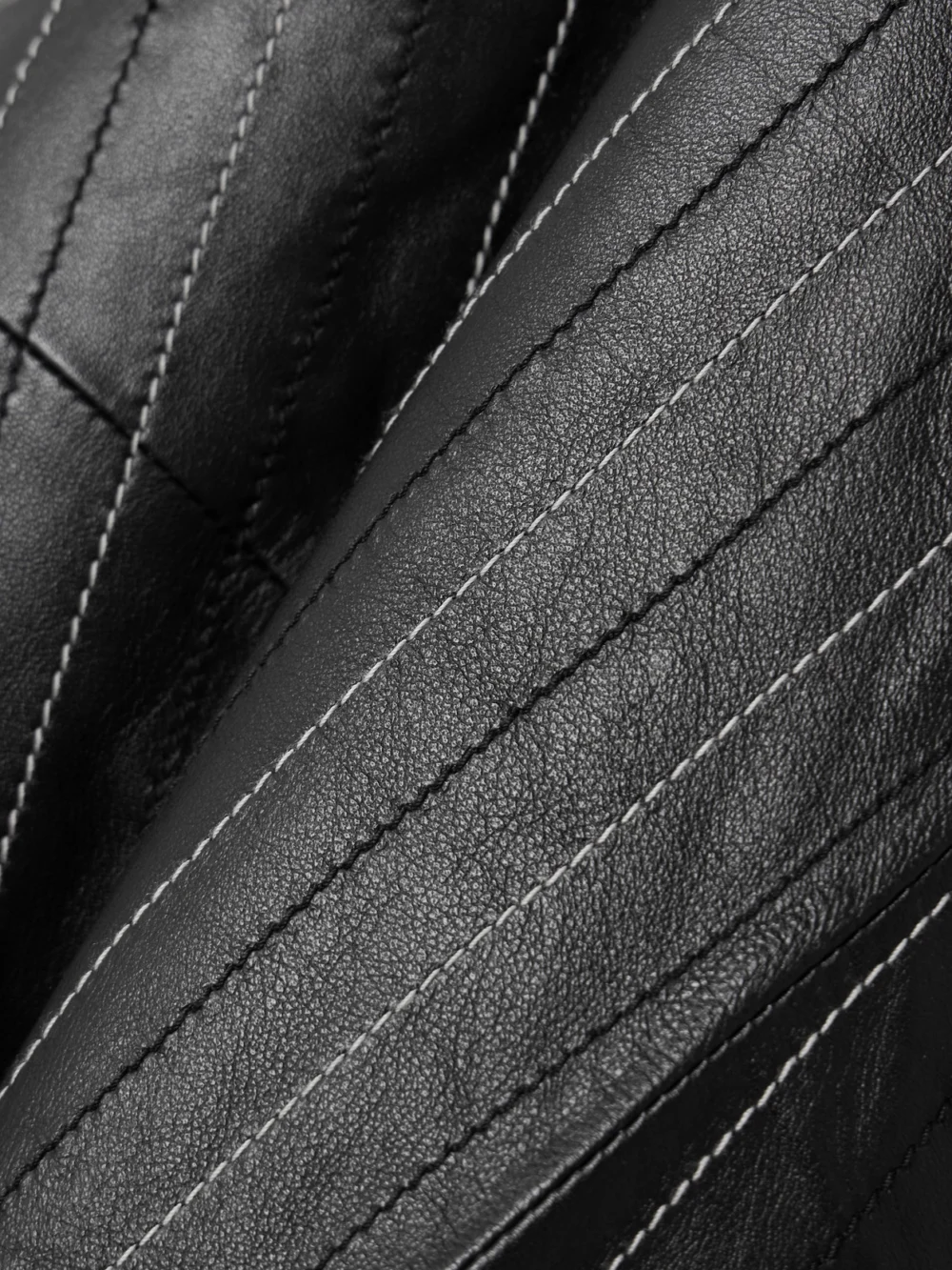 Close-up detail of the Victoria Beckham Paneled Embroidered Pinstriped Leather Midi Skirt