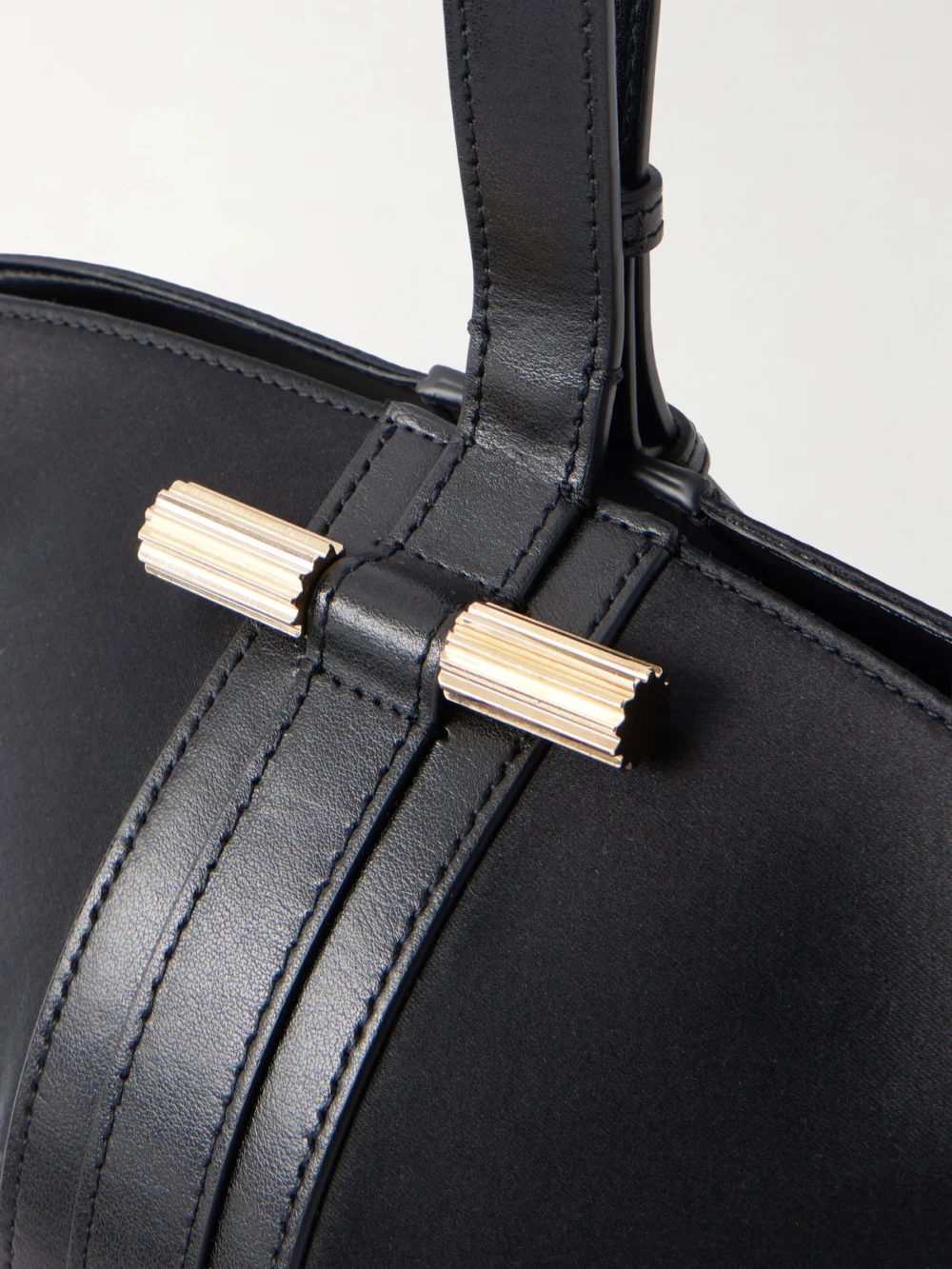 Close-up detail of the Victoria Beckham Portofina Dia Leather-trimmed Satin Clutch