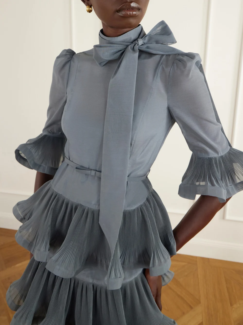 Close-up detail of the Zimmermann Pussy-bow Ruched Tiered Plissé Organza Midi Dress