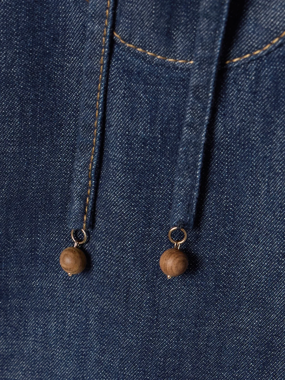 Close-up detail of the Zimmermann Rhiannon Tie-detailed Frayed Denim Mini Dress