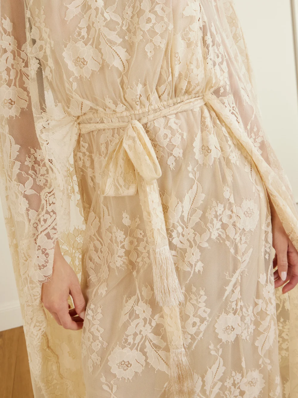 Close-up detail of the Zimmermann Valiant Belted Cape-effect Lace Maxi Dress