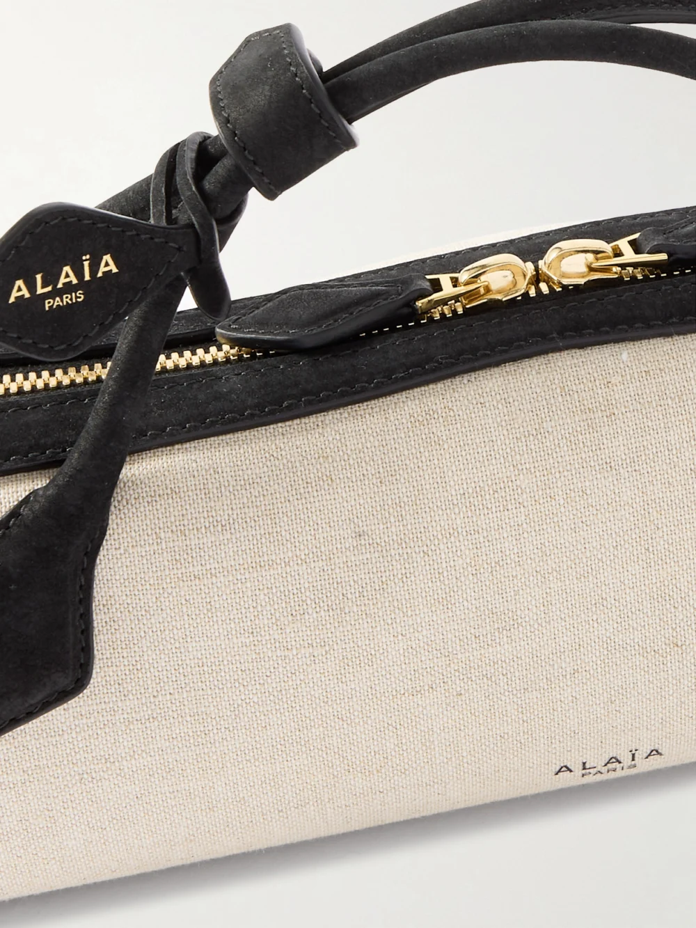 Close-up detail of the Alaïa Le Teckel Leather-trimmed Canvas Clutch