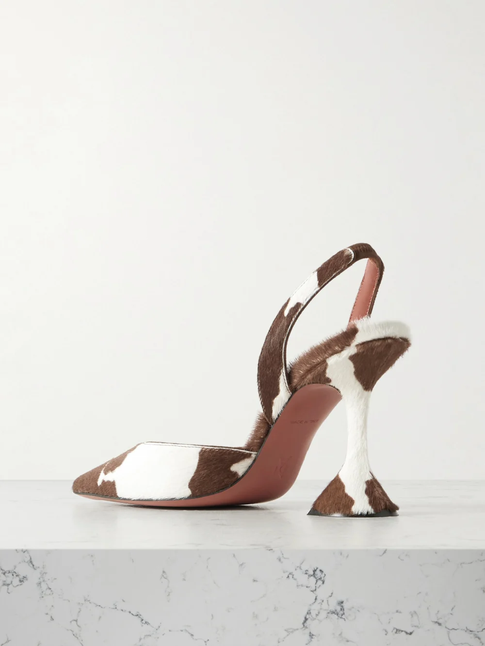 Back view of the Amina Muaddi Holli 95 Cow-print Calf Hair Slingback Pumps