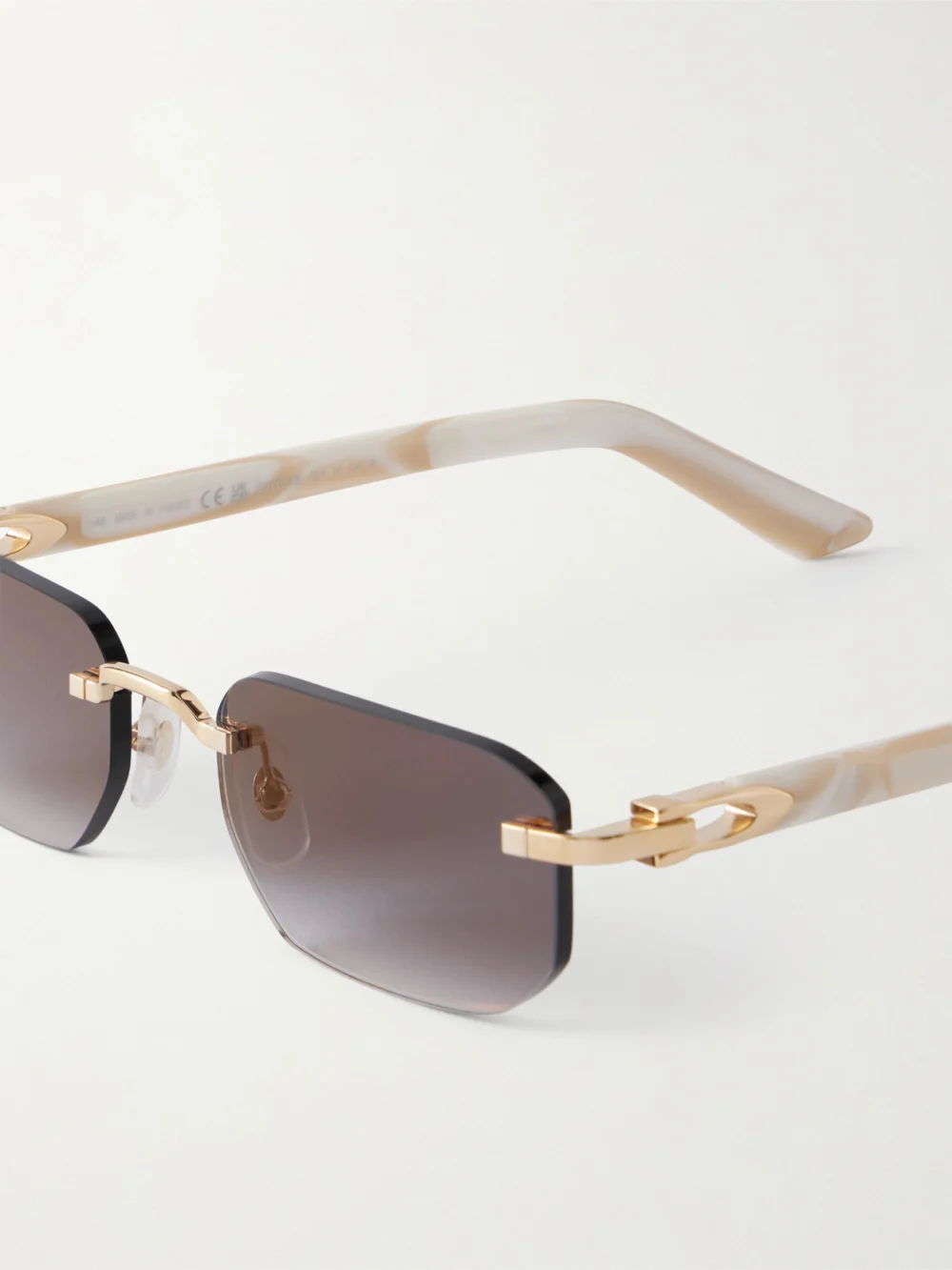 Close-up detail of the Cartier Eyewear Signature C Rimless Rectangular-frame Gold-tone and Acetate Sunglasses