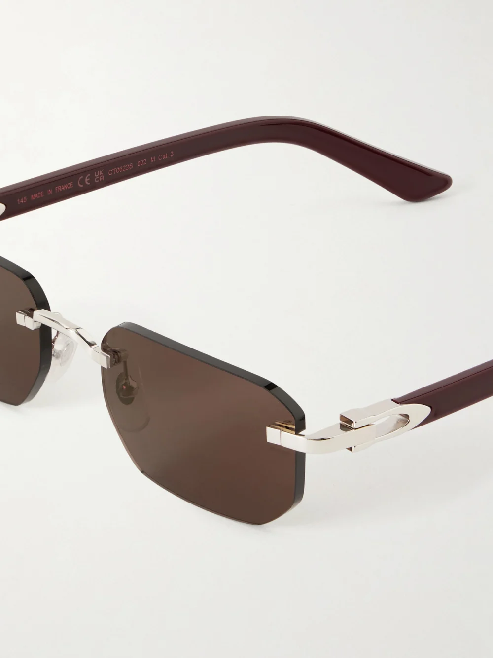 Close-up detail of the Cartier Eyewear Signature C Rimless Rectangular-frame Silver-tone and Acetate Sunglasses