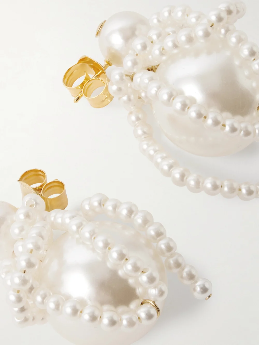 Close-up detail of the Completedworks Gold-plated Pearl-like Earrings