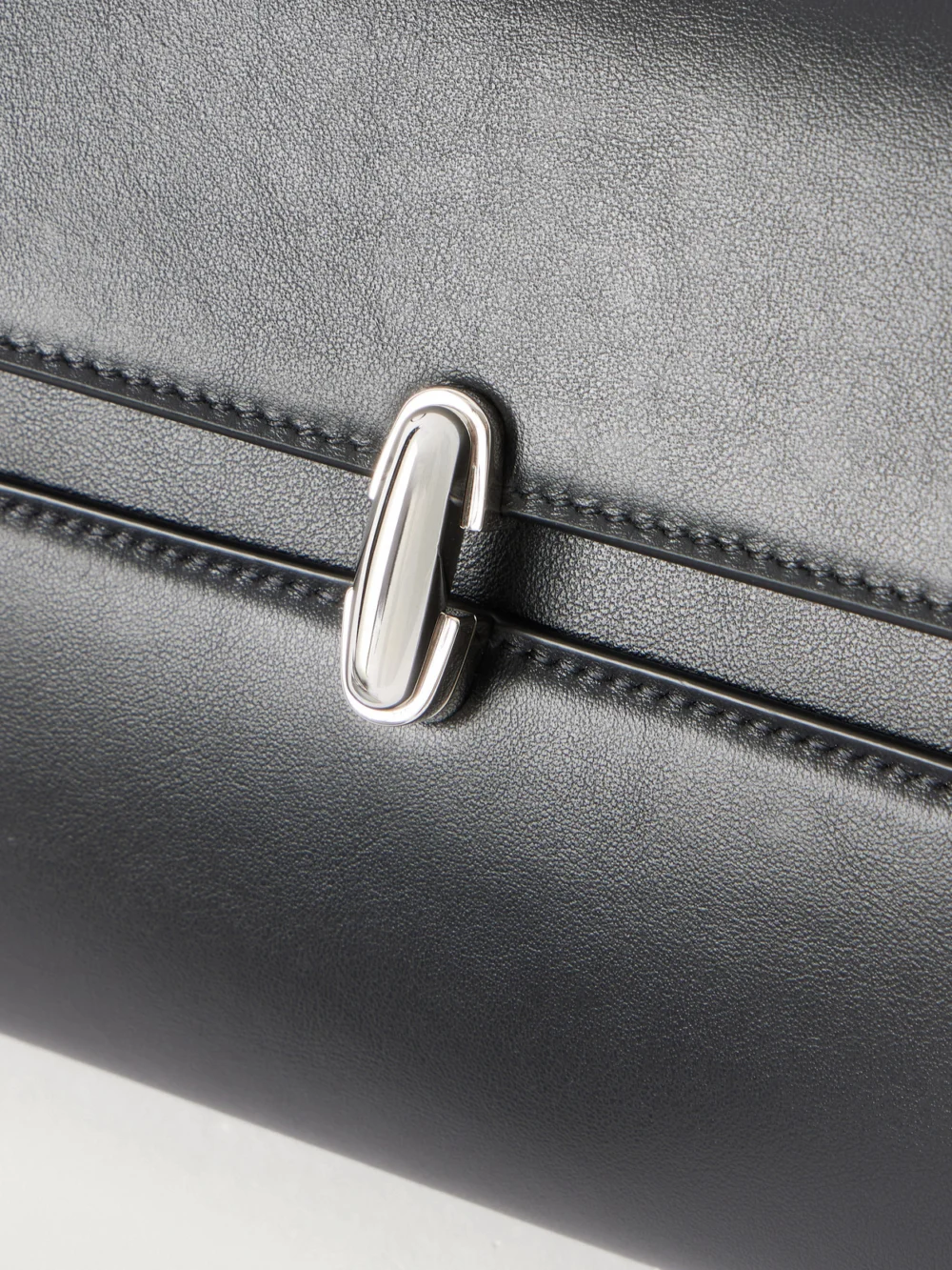 Close-up detail of the Savette Symmetry Trapeze Pochette Leather Top-handle Bag