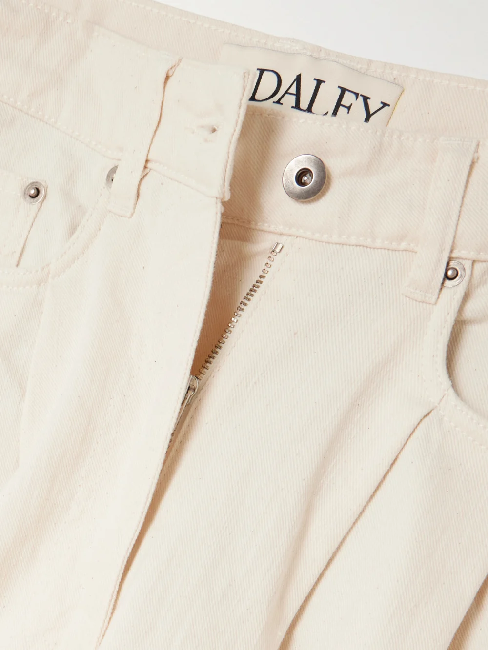 Close-up detail of the S.S. Daley Ivy Pleated Cropped Mid-rise Barrel-leg Jeans