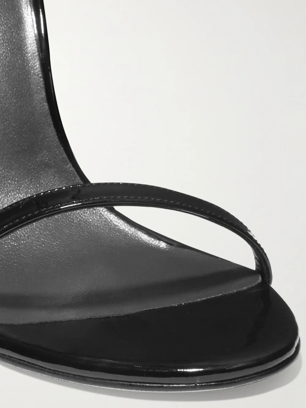 Close-up detail of the Stuart Weitzman Nudistsong Patent-leather Sandals