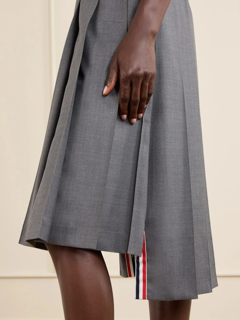 Close-up detail of the Thom Browne Asymmetric Grosgrain-trimmed Pleated Wool Midi Skirt
