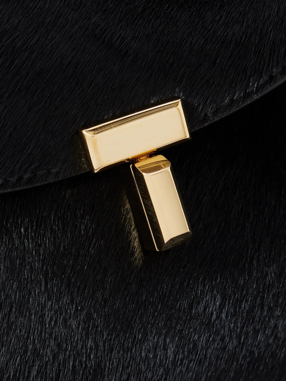 Close-up detail of the Totême T-lock Leather-trimmed Pony Hair Shoulder Bag