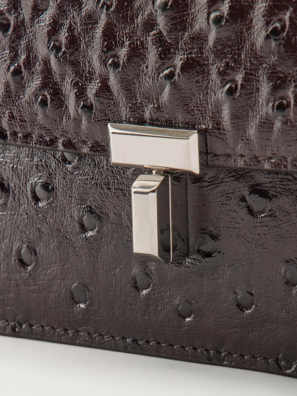 Close-up detail of the Totême T-lock Ostrich-effect Leather Shoulder Bag