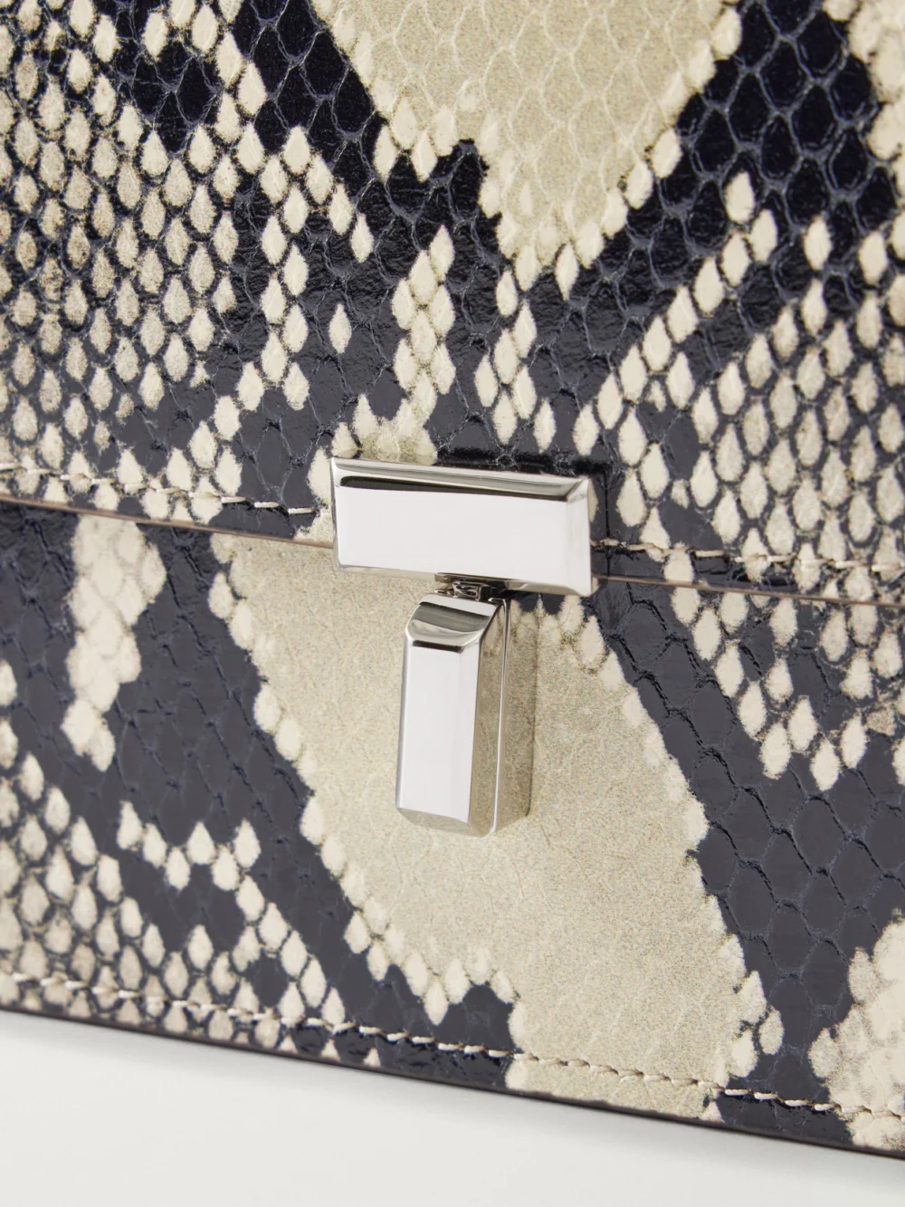 Close-up detail of the Totême T-lock Snake-effect Leather Shoulder Bag