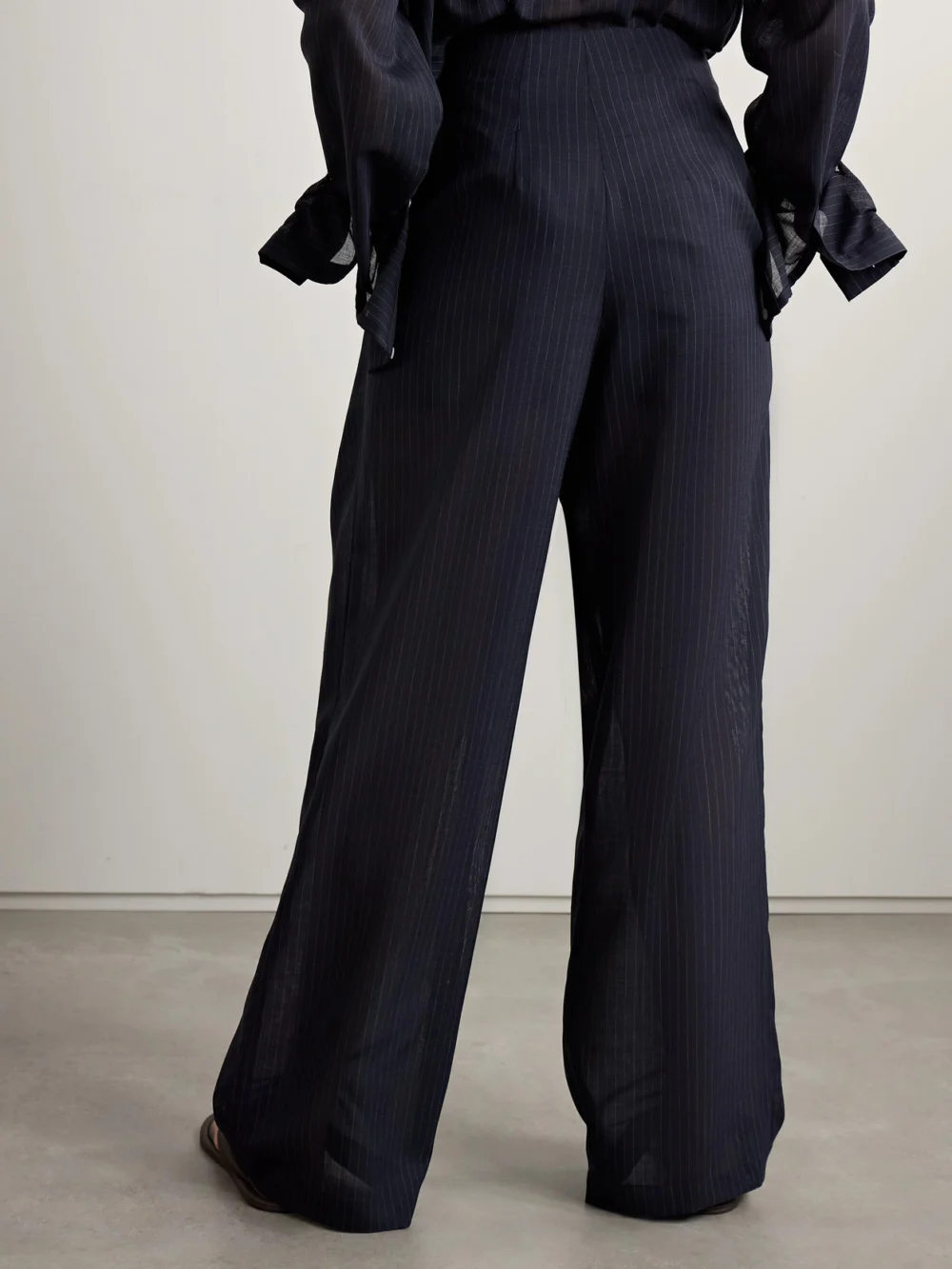 Back view of the Twp Carrie's Pleated Pinstriped Wool Wide-leg Pants