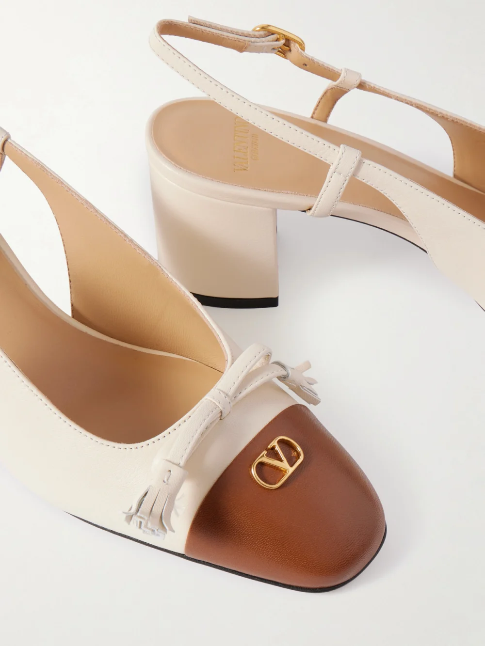 Close-up detail of the Valentino Garavani Vlogo 65 Tasseled Leather Slingback Pumps