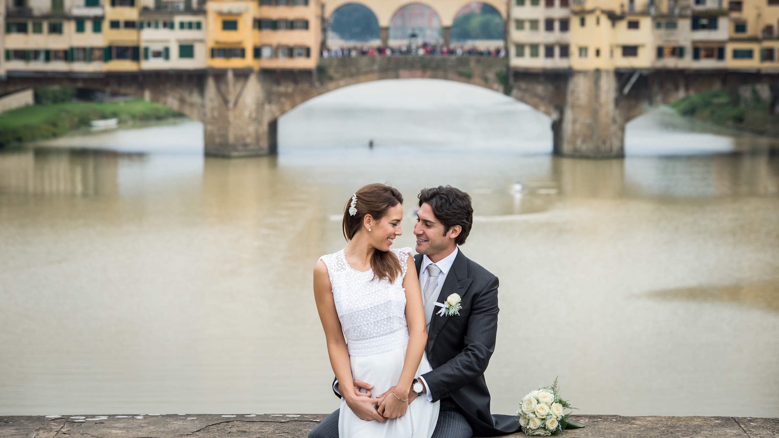 A couple beside the Arno and the Ponte Vecchio