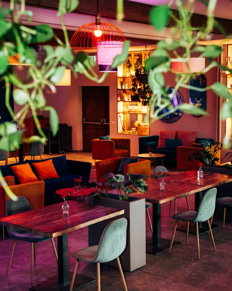 The Lab Botanico cocktail bar and lounge, with hanging plants over red tables, Borgo Antichi Orti Assisi