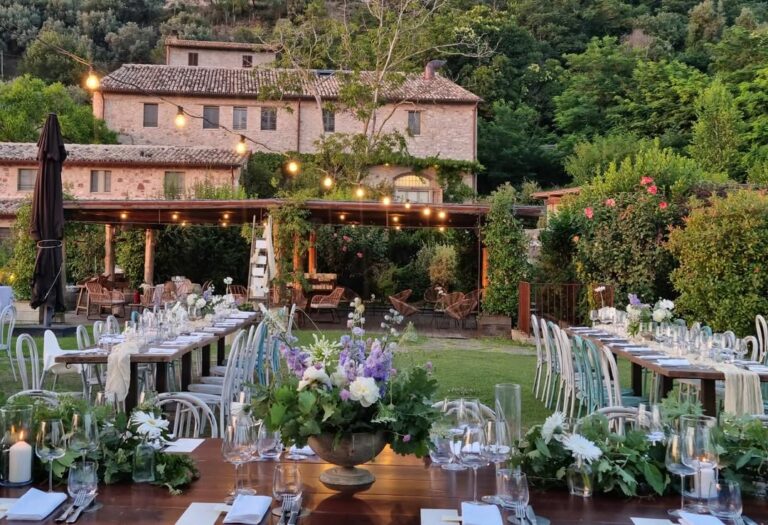 Long tables dressed with flowers and candles in the garden, in front of the borgo's main house, Borgo Antichi Orti Assisi