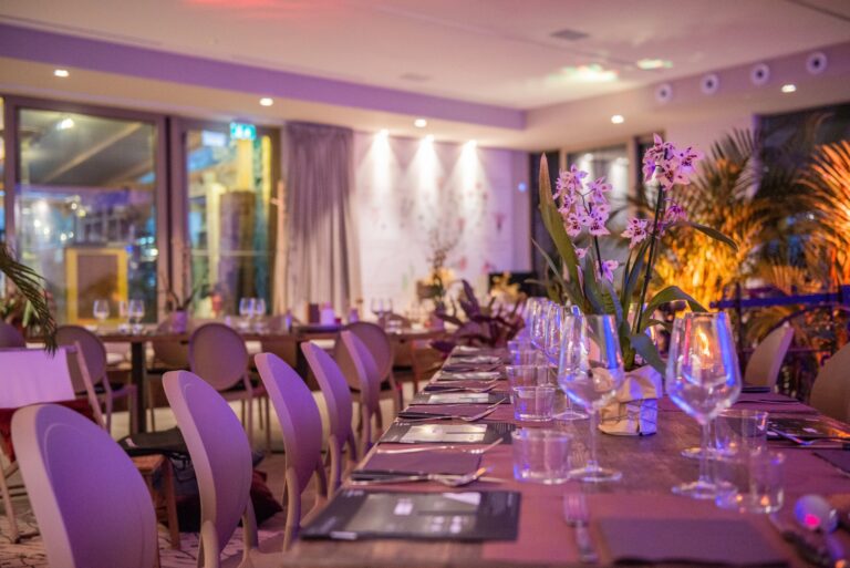 A long dinner table set with orchids and candles inside the Lab Botanico, Borgo Antichi Orti Assisi