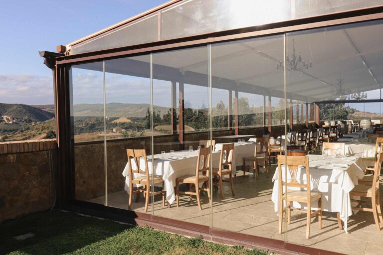 The glazed terrace of the Settimo Senso restaurant, laid for dinner, Castello di Velona Resort