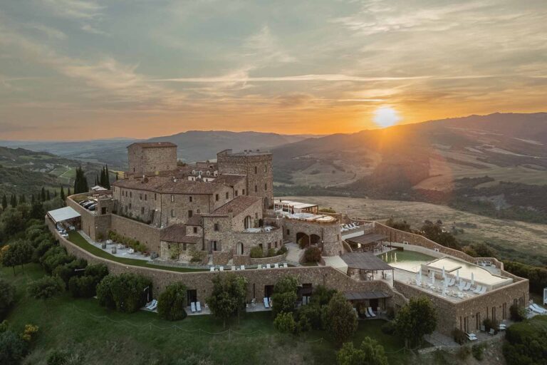 The castle on its hilltop at sunset, seen from the air, Castello di Velona Resort
