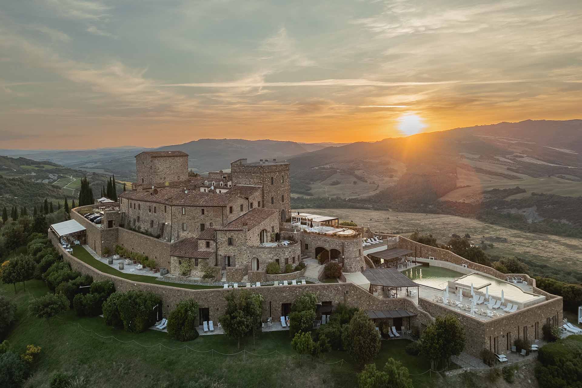 The castle on its hilltop at sunset, seen from the air, Castello di Velona Resort