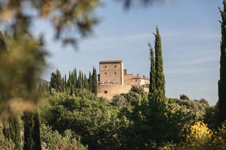 The castle tower framed by cypresses and broom, Castello di Velona Resort