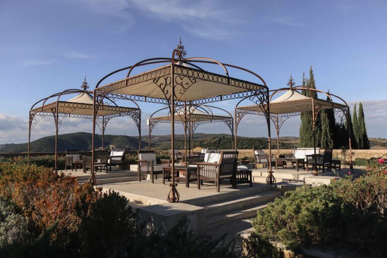 Wrought-iron gazebos on a terrace facing the hills, Castello di Velona Resort