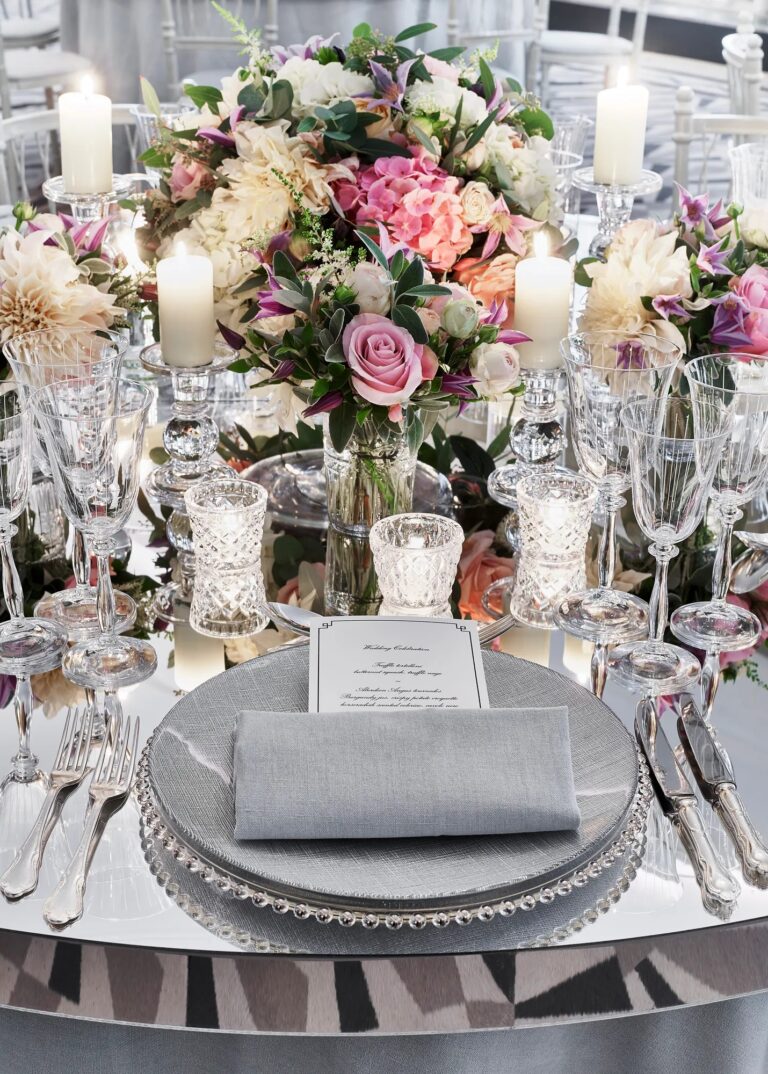A wedding place setting with a silver charger, crystal glasses and pink and white flowers, Claridge's