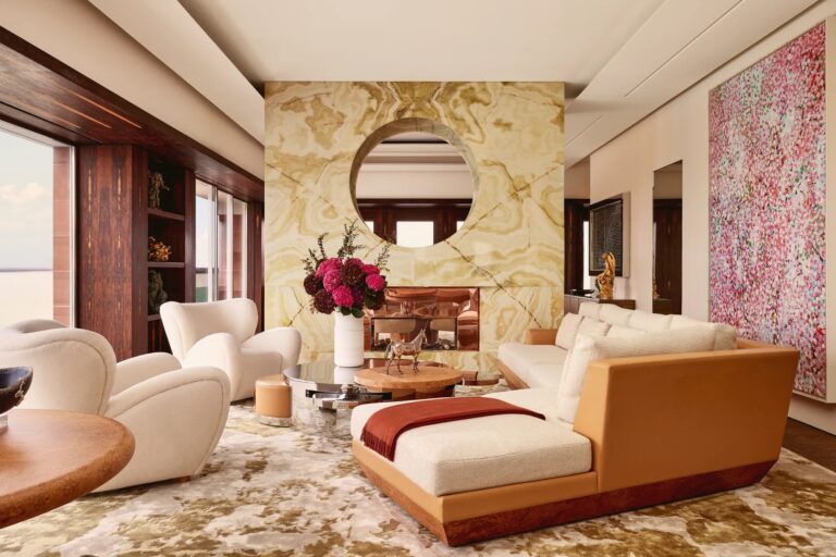 A living room in The Penthouse with curved sofas, a circular mirror and a large abstract painting, Claridge's