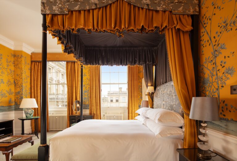 A Deluxe Double Room with a four-poster bed and yellow chinoiserie wallpaper, Cliveden House