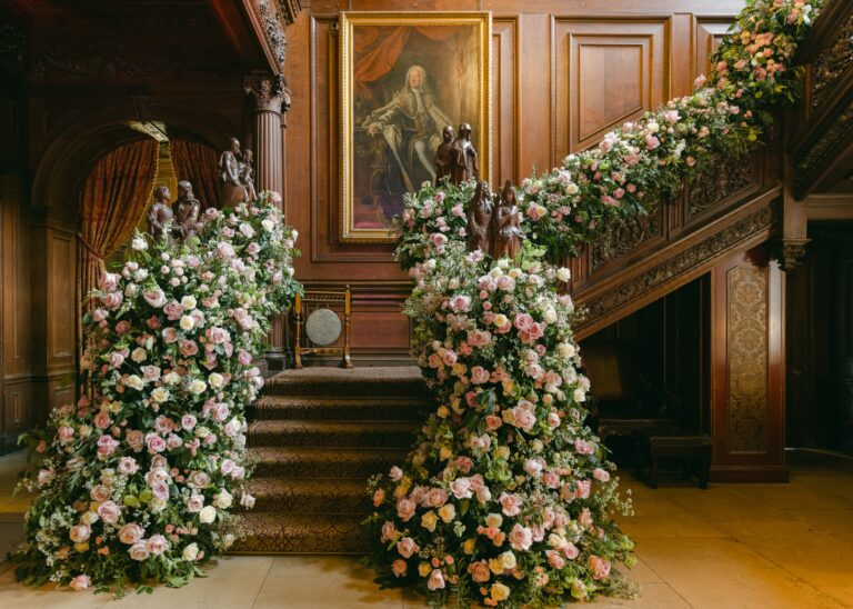 The carved oak staircase in the Great Hall dressed with cascades of pink and cream roses, Cliveden House