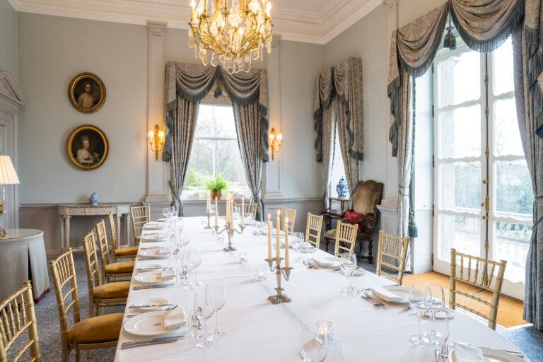 The Boudoir laid for a private dinner, with blue-grey drapes and tall windows onto the Parterre, Cliveden House