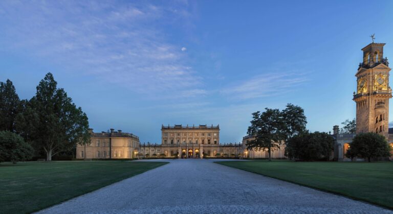 The main drive at dusk, leading to the lit south front of the house, with the clock tower on the right, Cliveden House