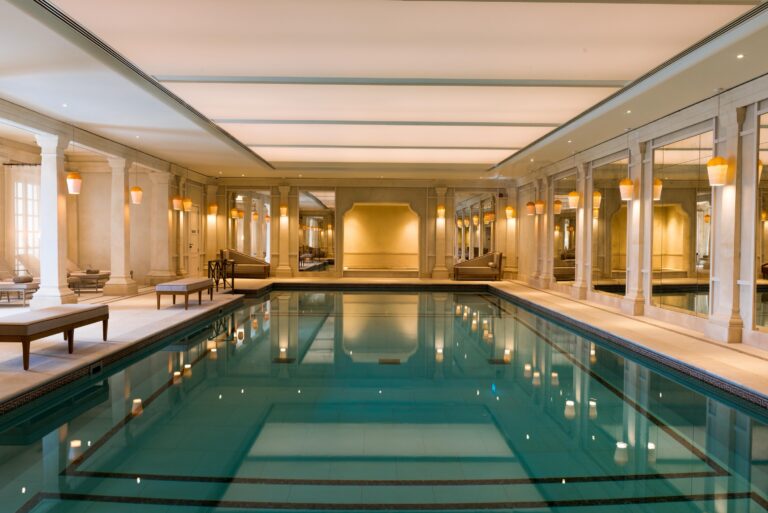 The indoor swimming pool in The Cliveden Spa, lined with columns and loungers, Cliveden House