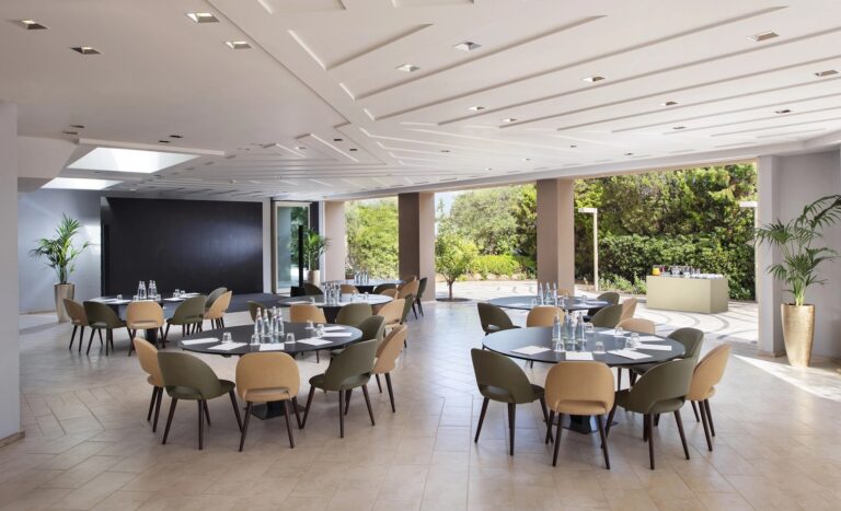 The Conrad Event Space set with round tables, opening onto the garden, Conrad Chia Laguna Sardinia