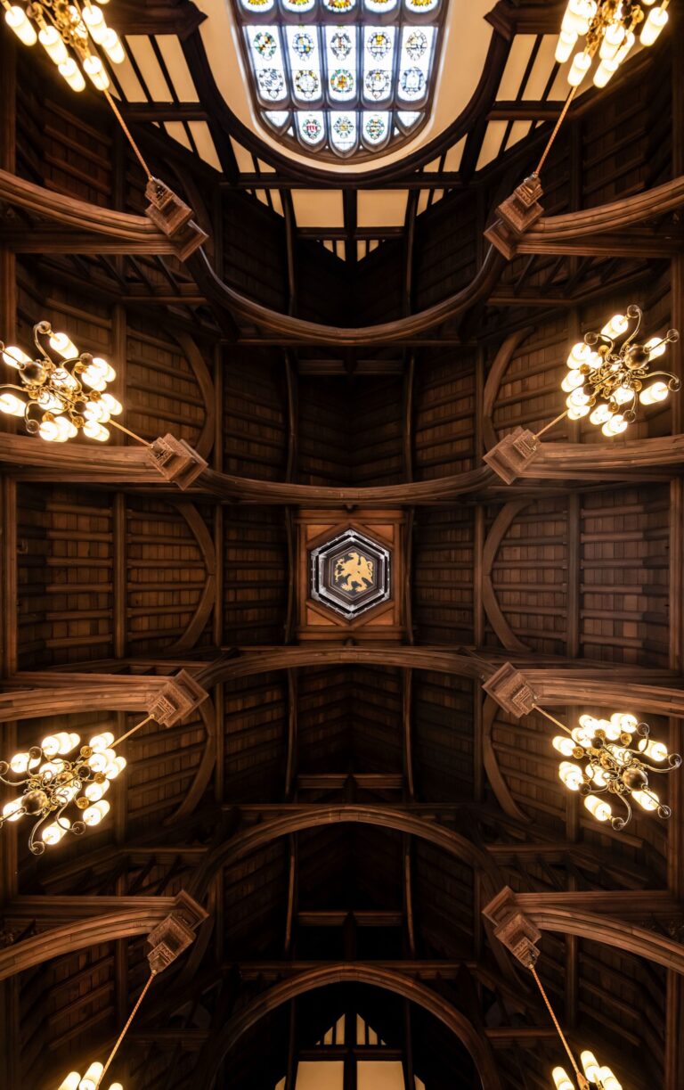 Looking up into the timber roof of the Hall, with its chandeliers and a coat of arms at the centre, Gray's Inn