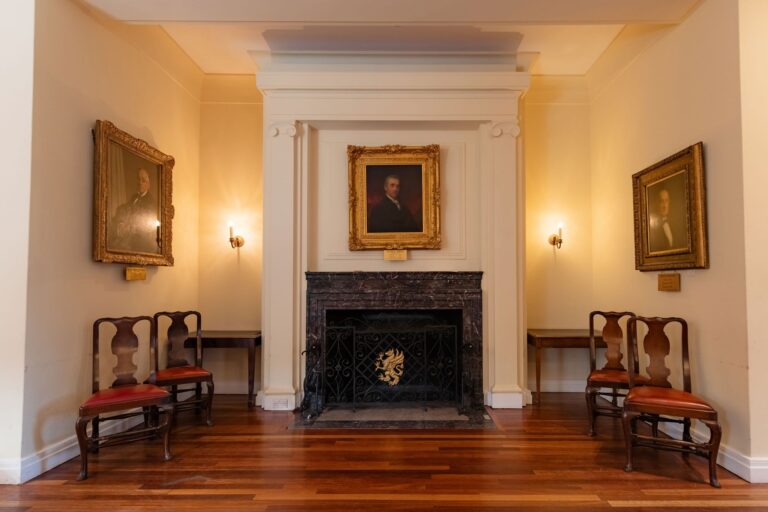 A marble fireplace with a gilt-framed portrait above it and chairs on either side, Gray's Inn
